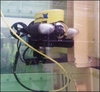 Image of ROV in test tank using boom to peer inside replica fuel skip